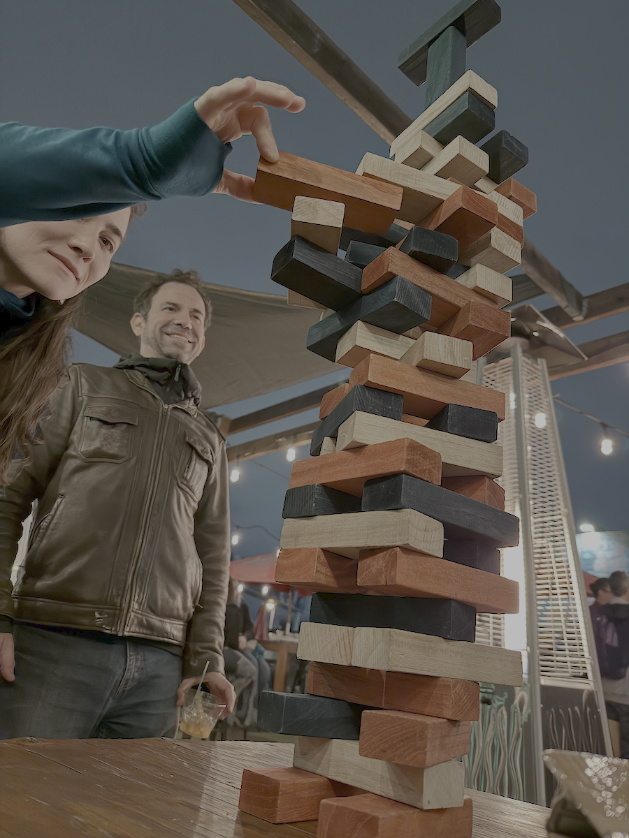 AI researchers playing Jenga, but the blocks at the top are in the wrong orientation — suggesting it isn't an ordinary game being played.
